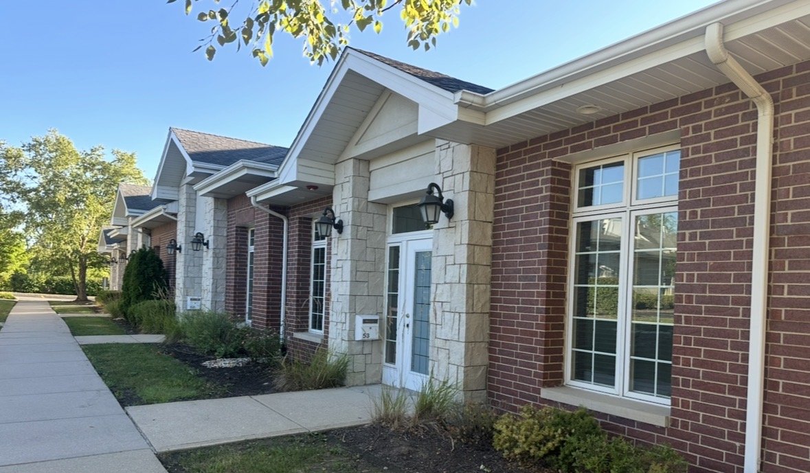 Brick office building exterior with landscaped walkway